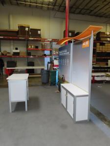 ecoSmart Sustainable ECO-1102 Exhibit with Backlit Fabric Graphic, Wave Canopy, Locking Backwall Cabinet, Monitor Mount, LED Lights, and MOD-1552 Reception Counter with Storage -- View 3